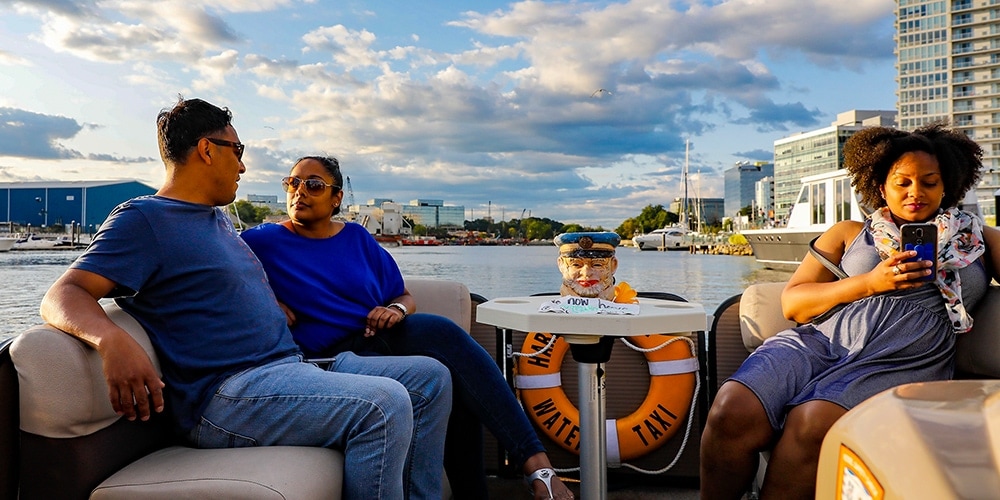2 women and a man enjoy a boat ride