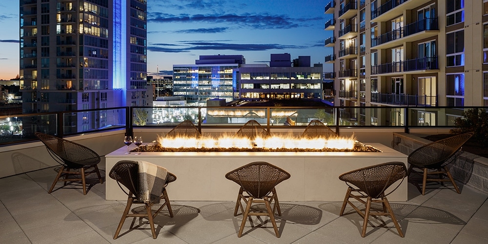 8 wicker chairs around a fire pit on a balcony