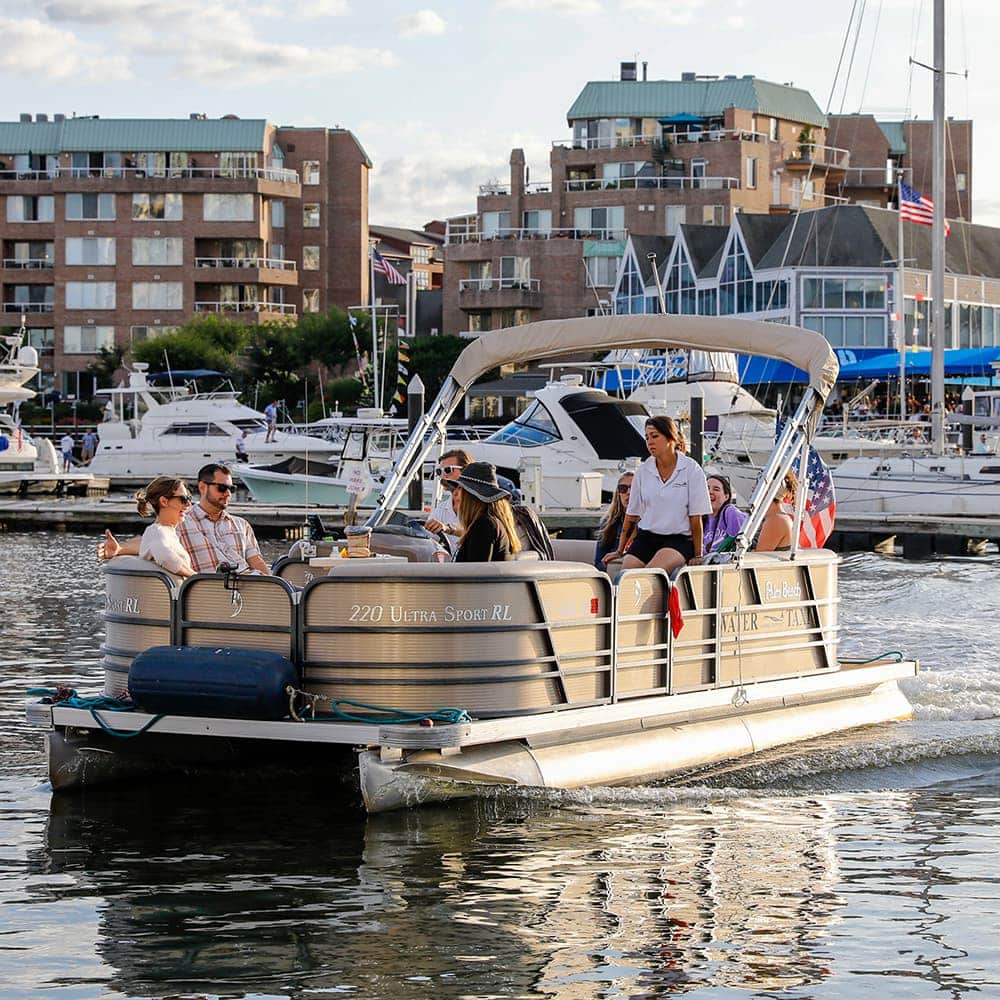 7 people ride a pontoon boat out of a marina